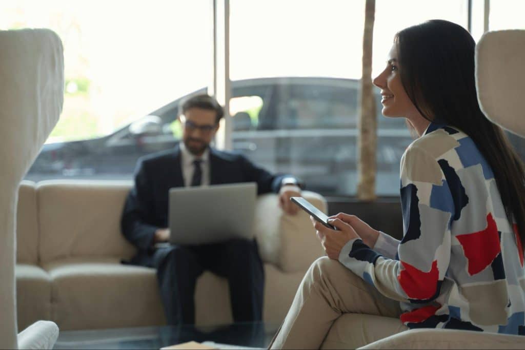 A man busy working and a woman sitting on a chair