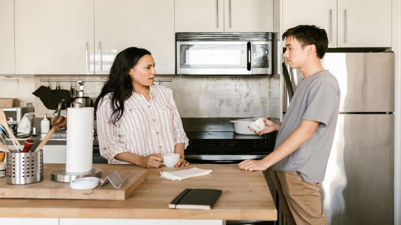A couple talking in the kitchen