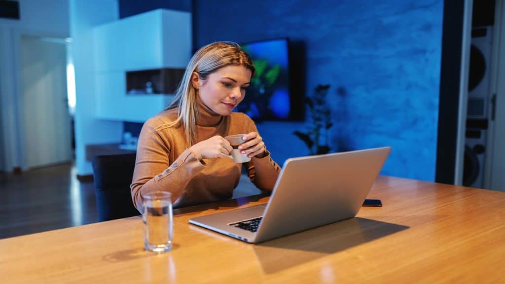 A woman looking at her laptop by herself