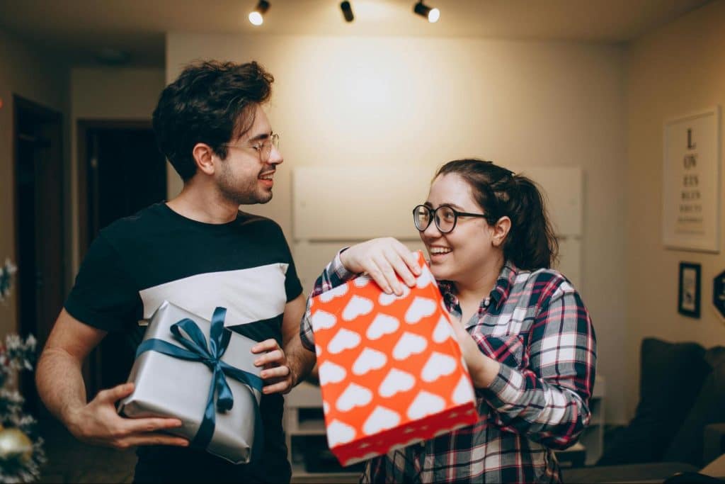 A man and woman giving gifts to each other