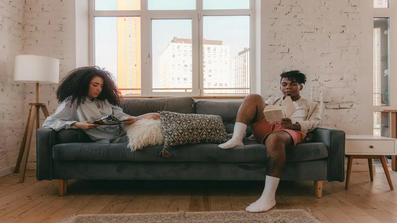 A couple ignoring each other in the living room