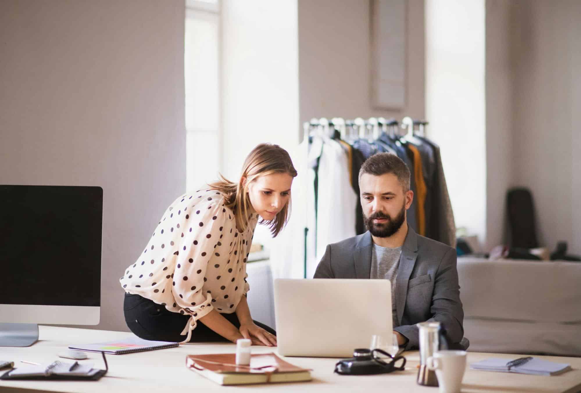 A man and woman seriously looking at the laptop