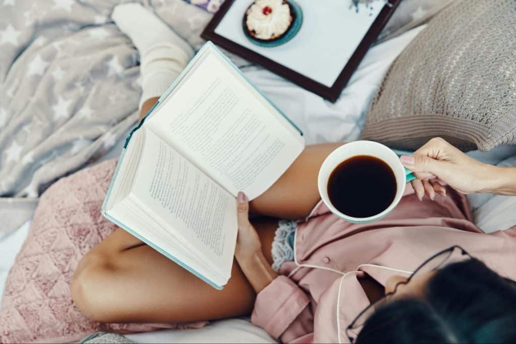 A woman reading a book while having a coffee