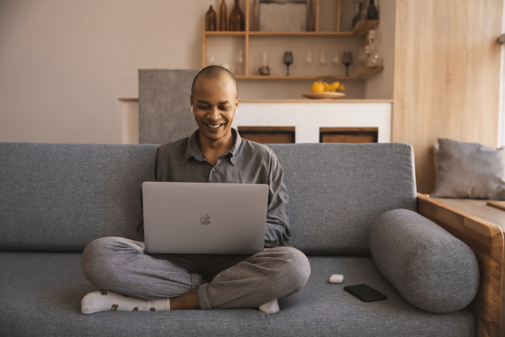 A man smiling while using a laptop
