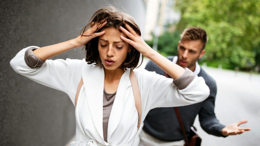 A couple arguing outdoors.