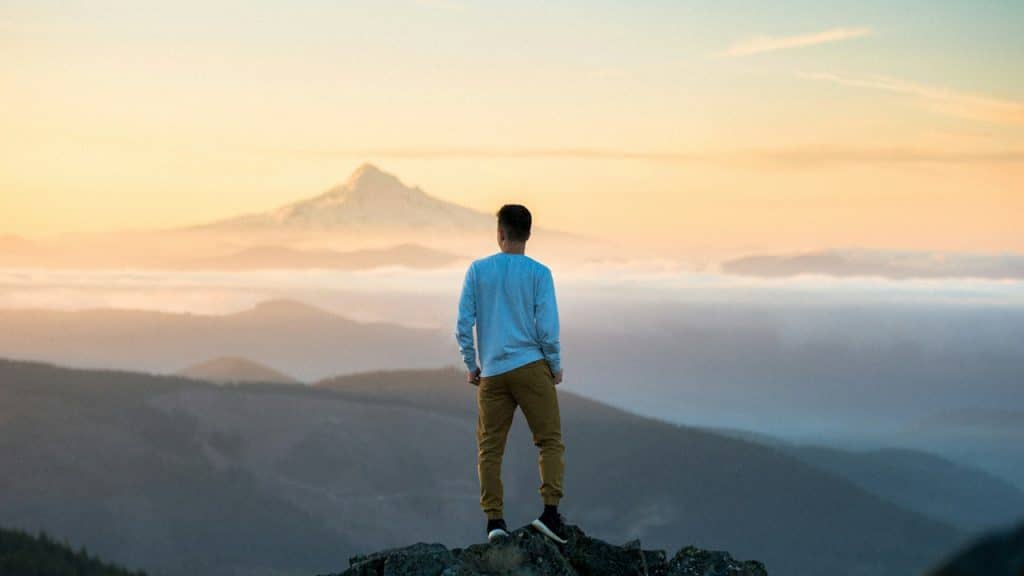 A man standing on the top of a mountain.