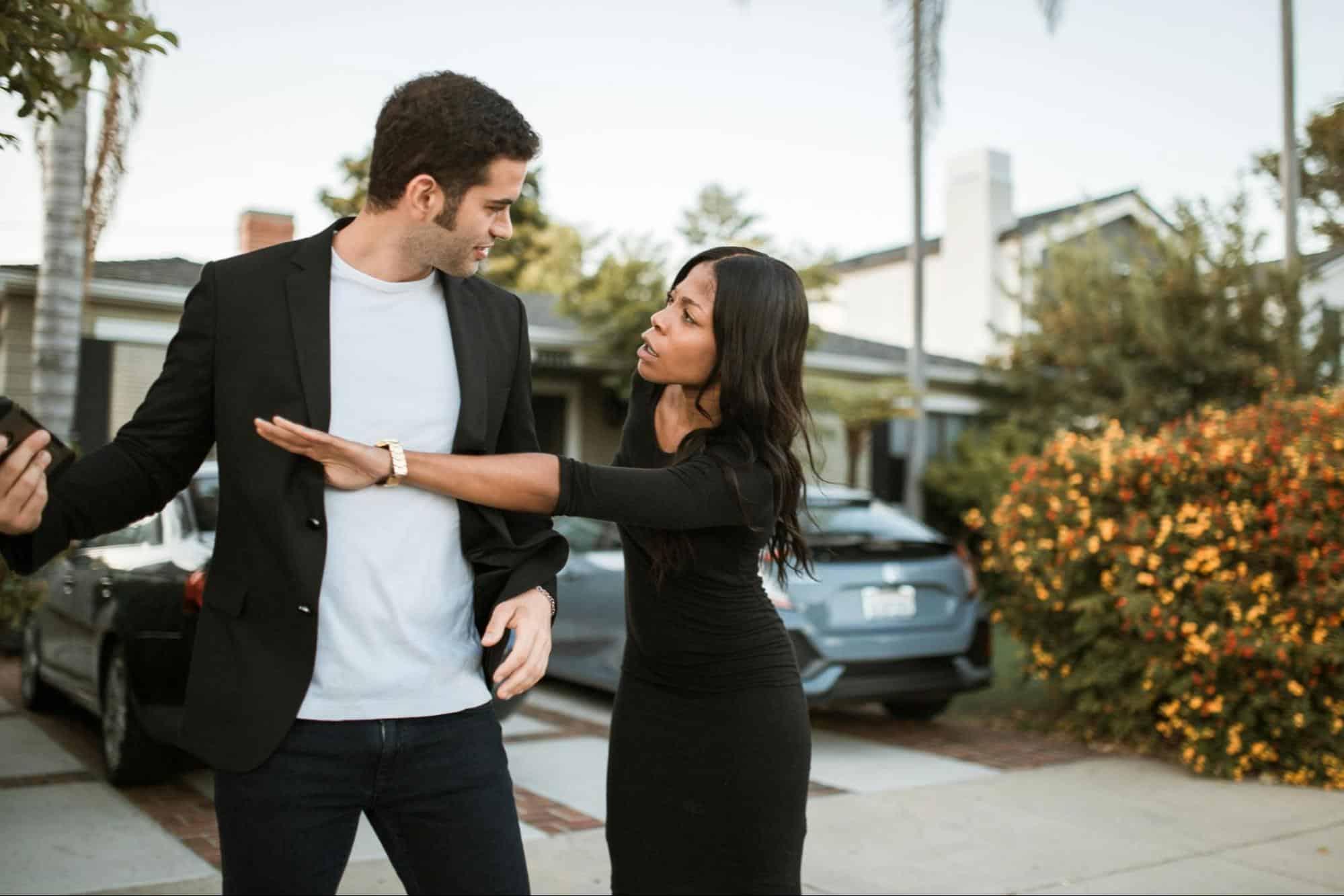 A man smirking while woman getting the phone on his hands