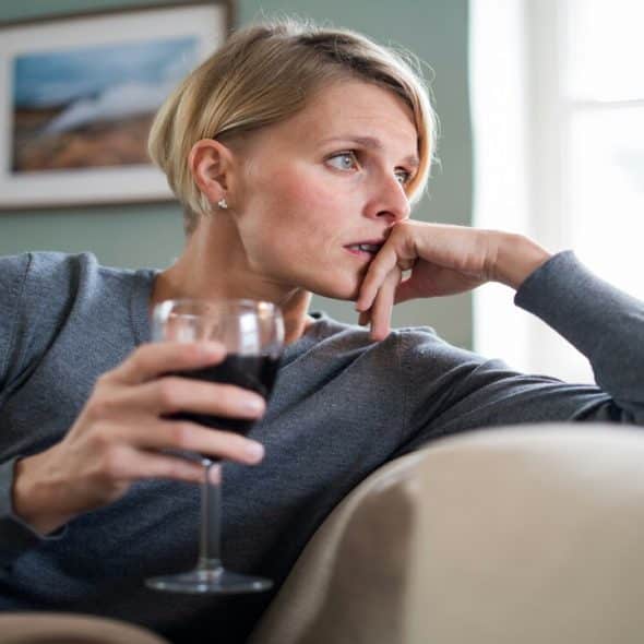 A woman looking stressed while drinking