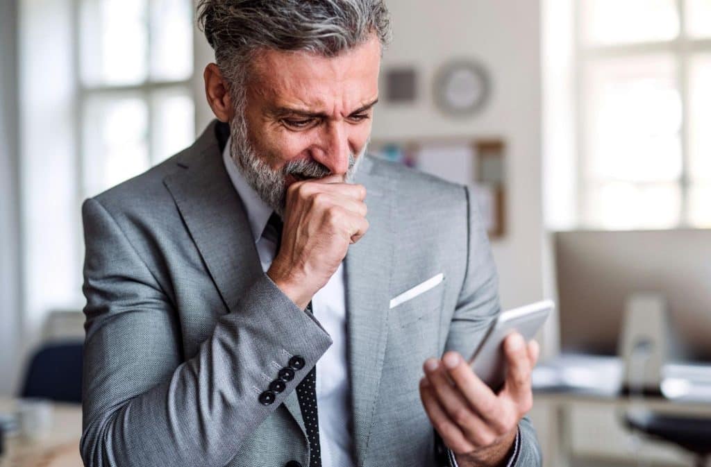 A man crying while looking at the phone