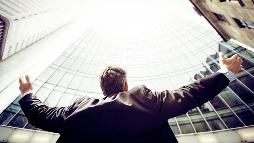 A man wearing a suit in the middle of buildings.