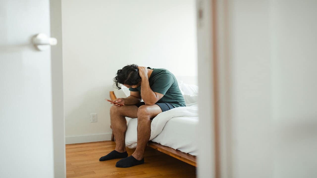 A sad man while looking at his phone