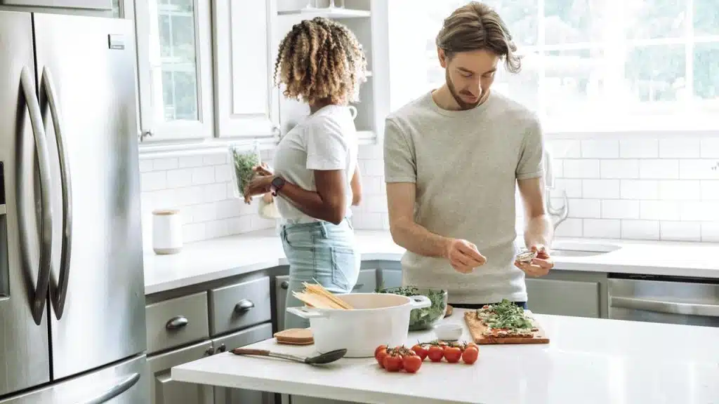 A couple preparing a meal together in a bright, modern kitchen.