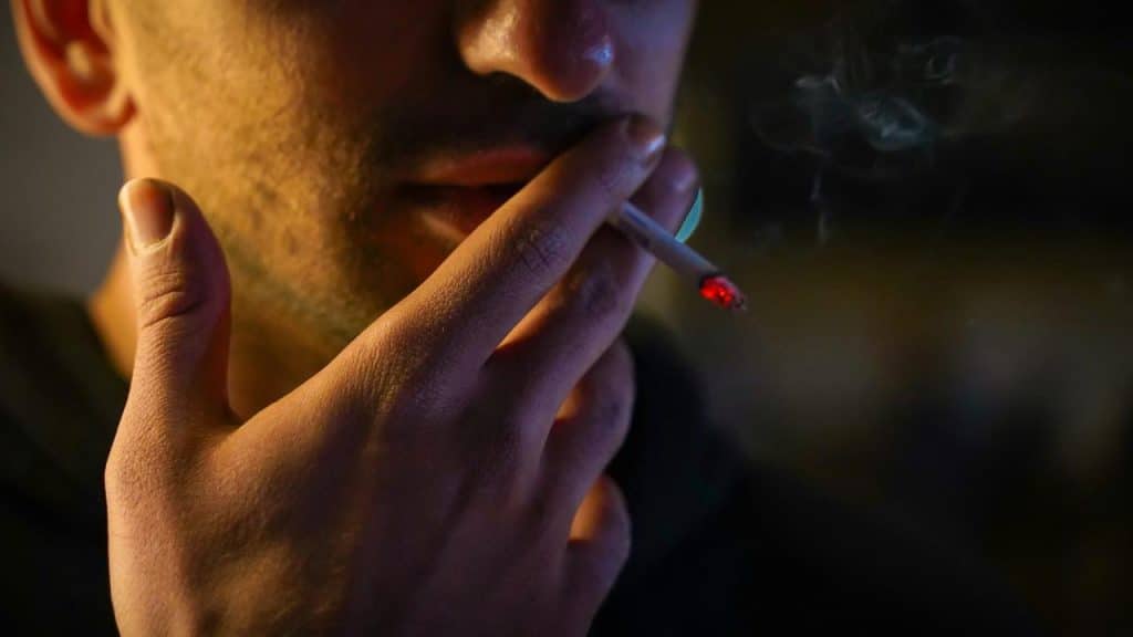A man smokes a lit cigarette.