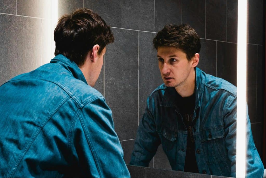 A man looking at himself at the mirror