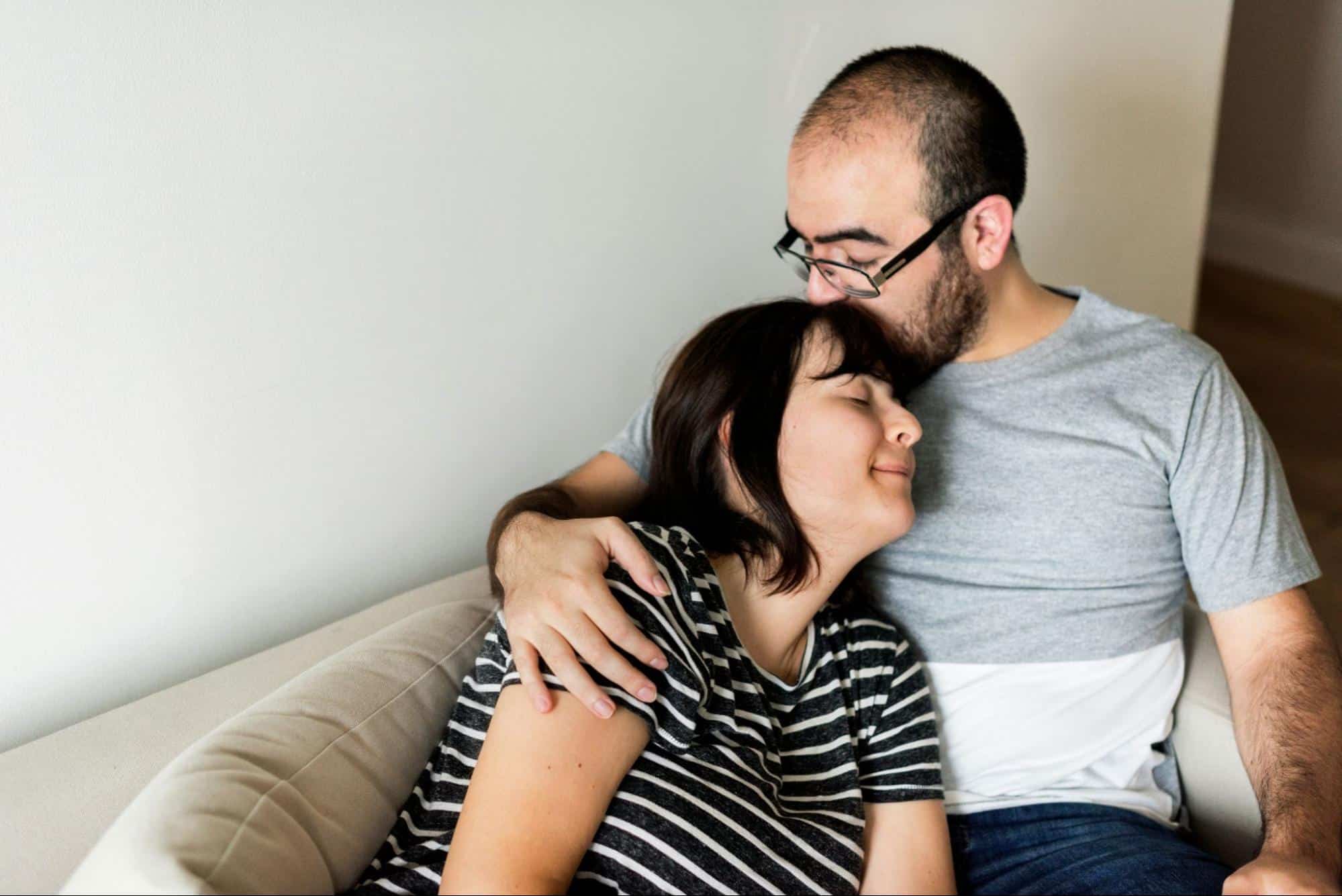 A man kissing a woman’s head