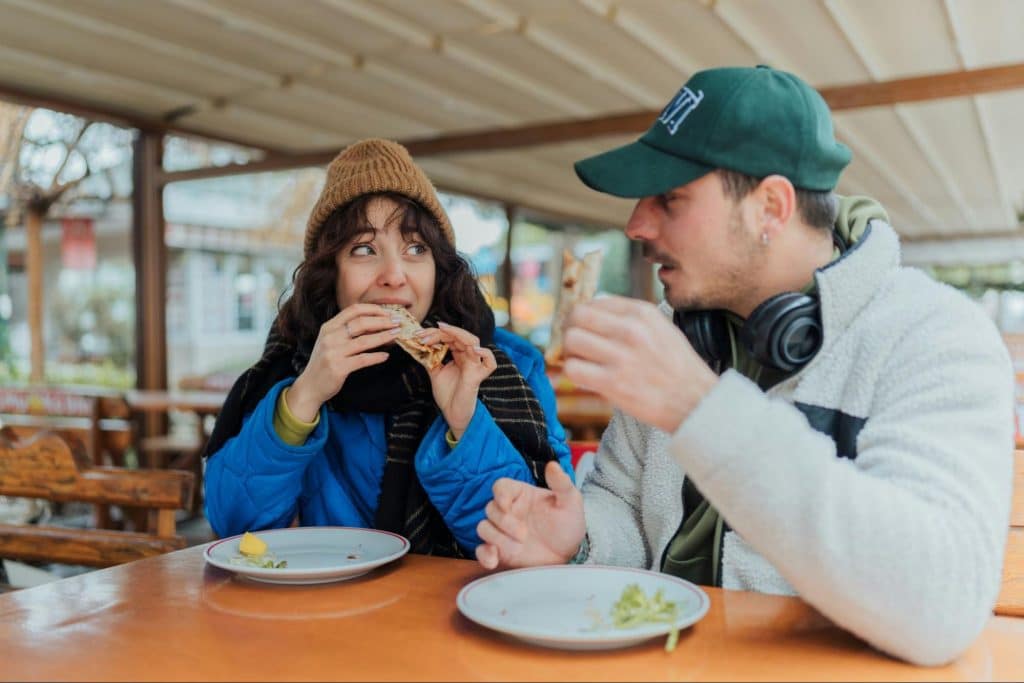 A man and woman eating while looking at each other