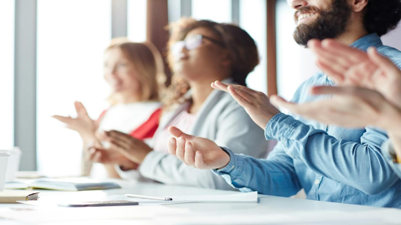Co-workers clapping at work