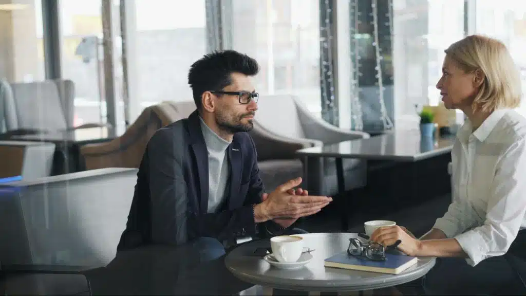 A man thinking and a woman talking to him