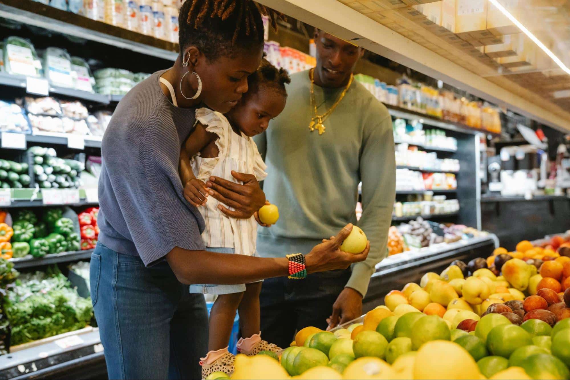 A man and woman at the grocery store with their baby