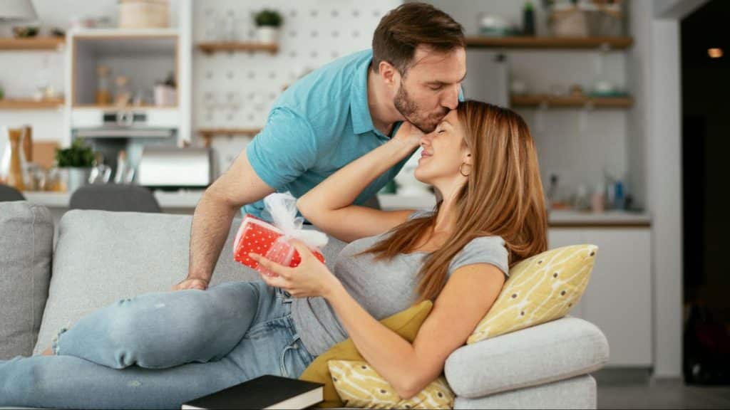 A man kissing woman’s head