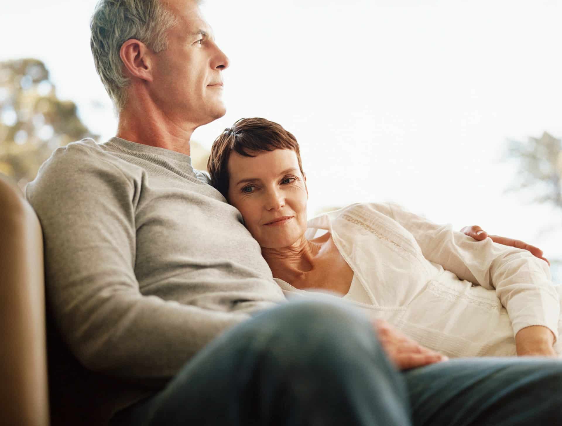 A mature couple sitting on a couch