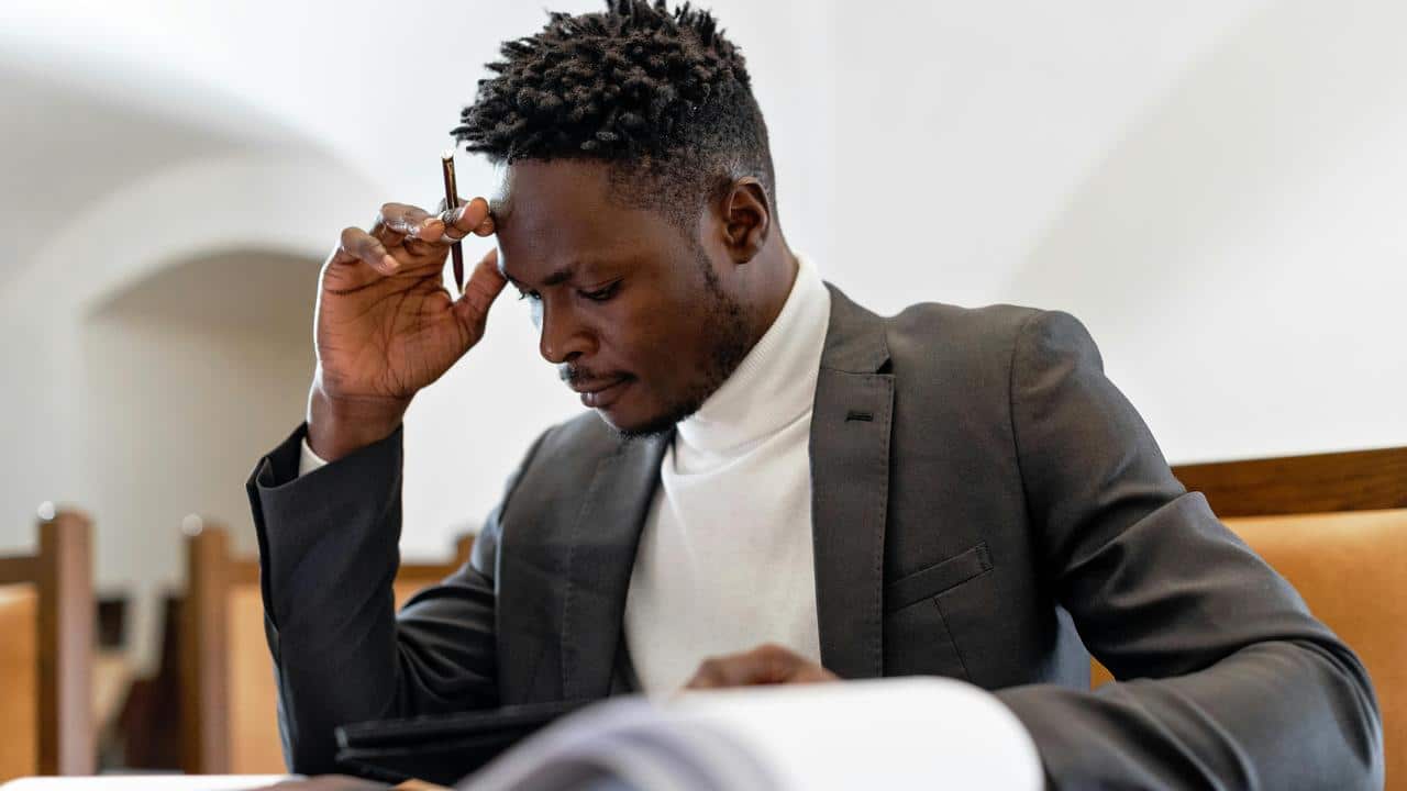 A man reading papers with a pen.