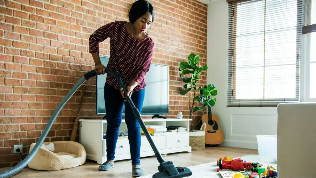 Woman using a vacuum to clean the house