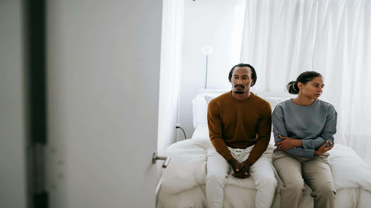 A couple looking sad in the bedroom