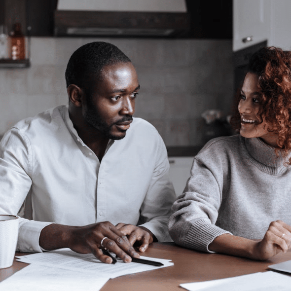 A Couple Sitting in Front of Laptop at Home