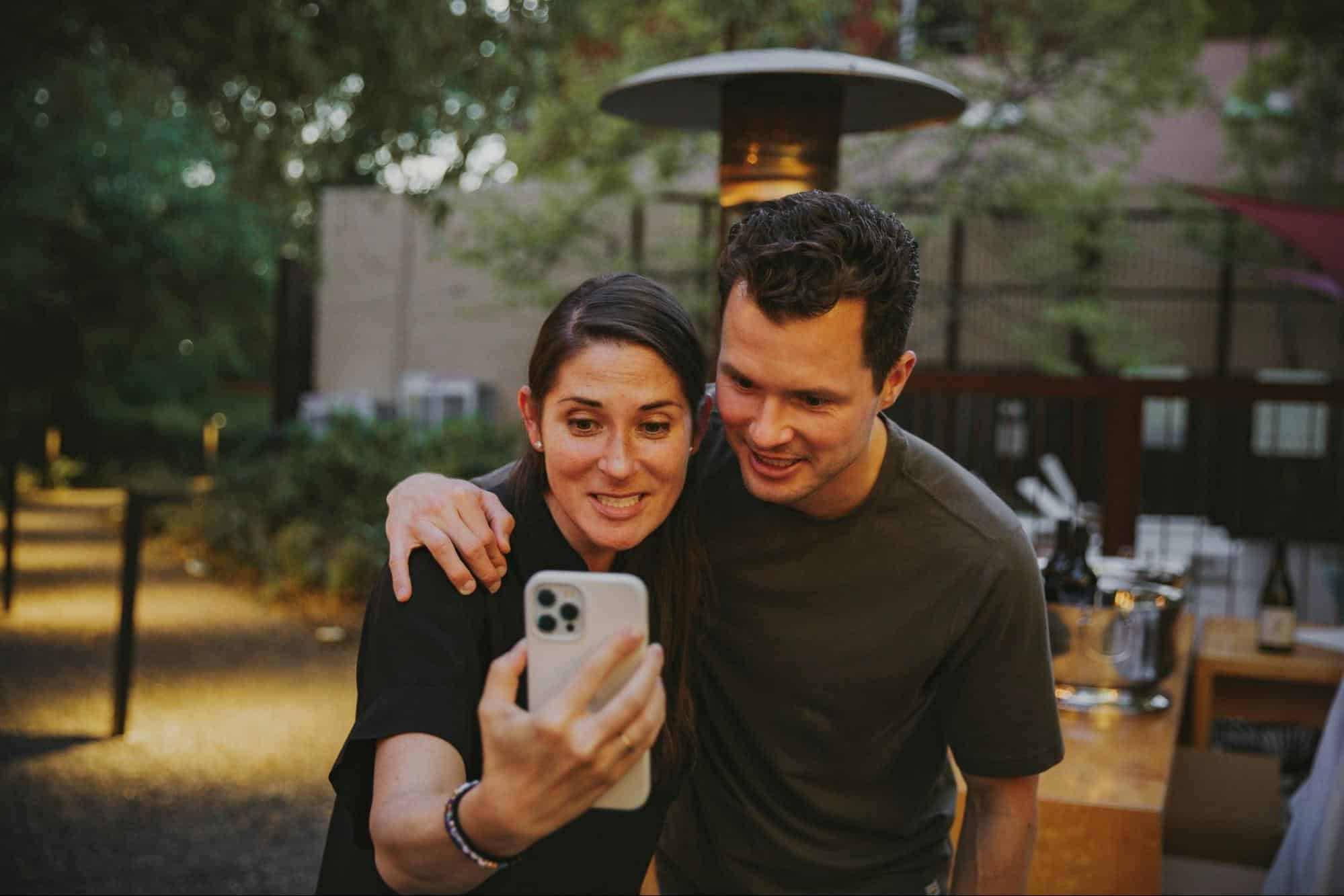 A man and woman taking a picture to post on social media