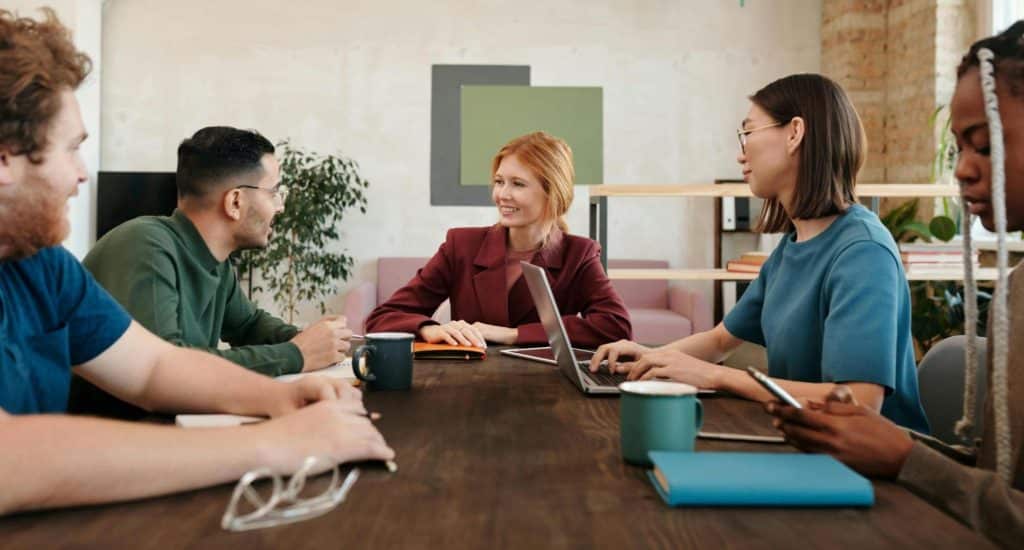 A man and woman talking in front of their colleagues