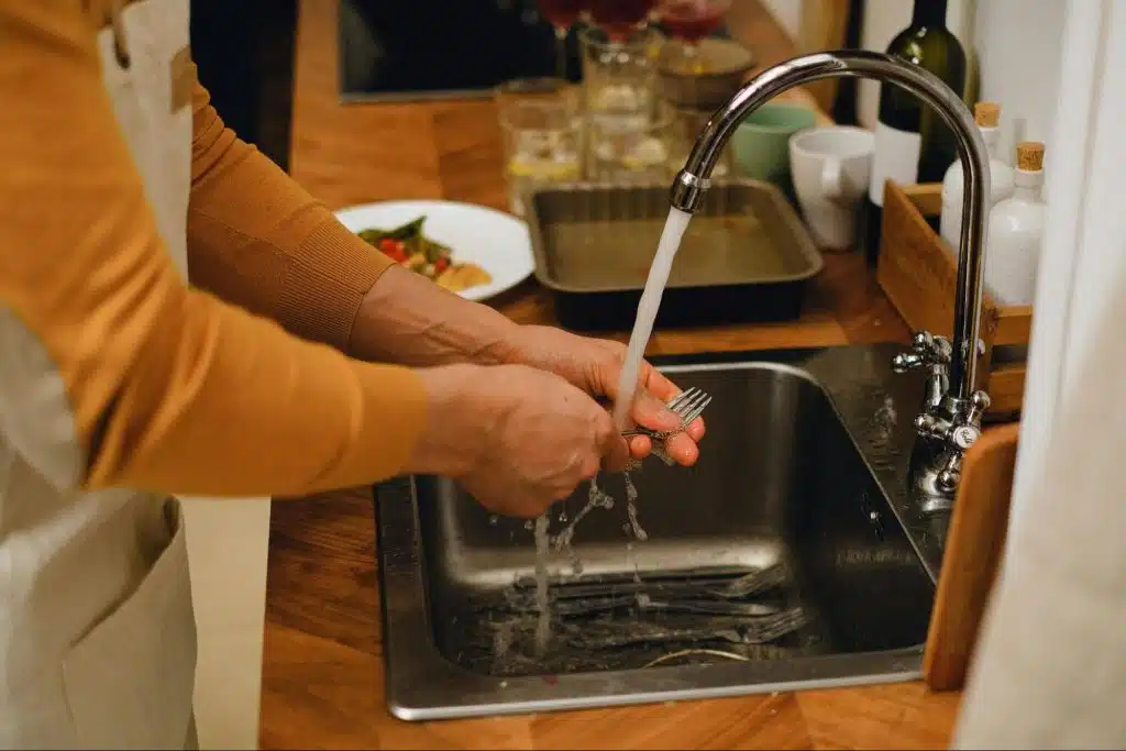 A person rinsing a fork