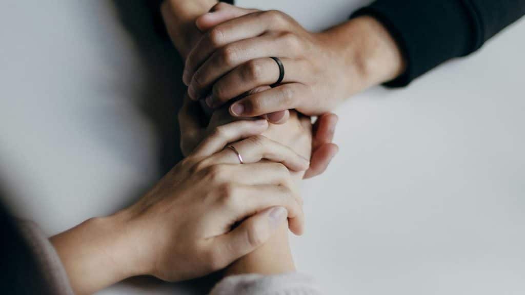 A pair of hands holding each other in support.