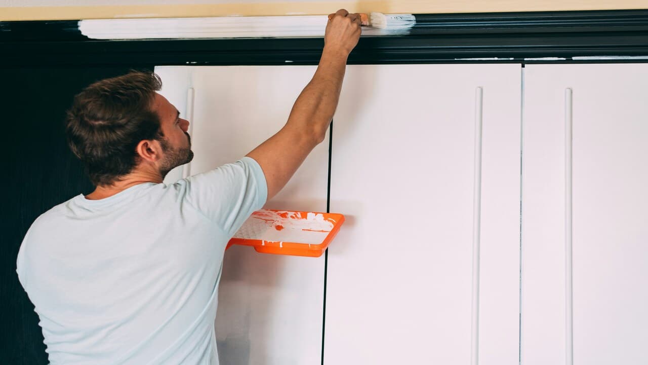 A man painting a wardrobe