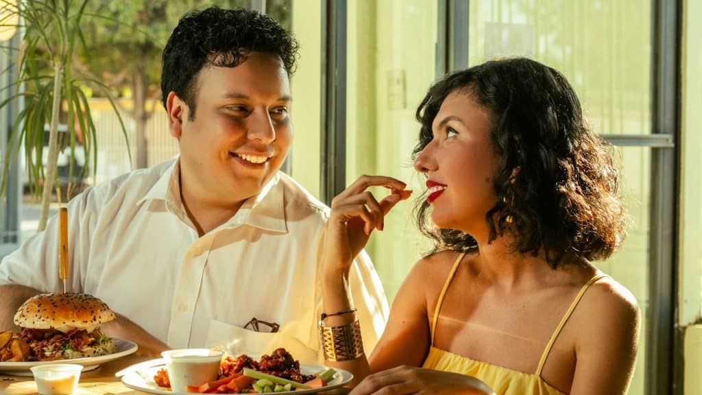 A couple shares food and laughs together.