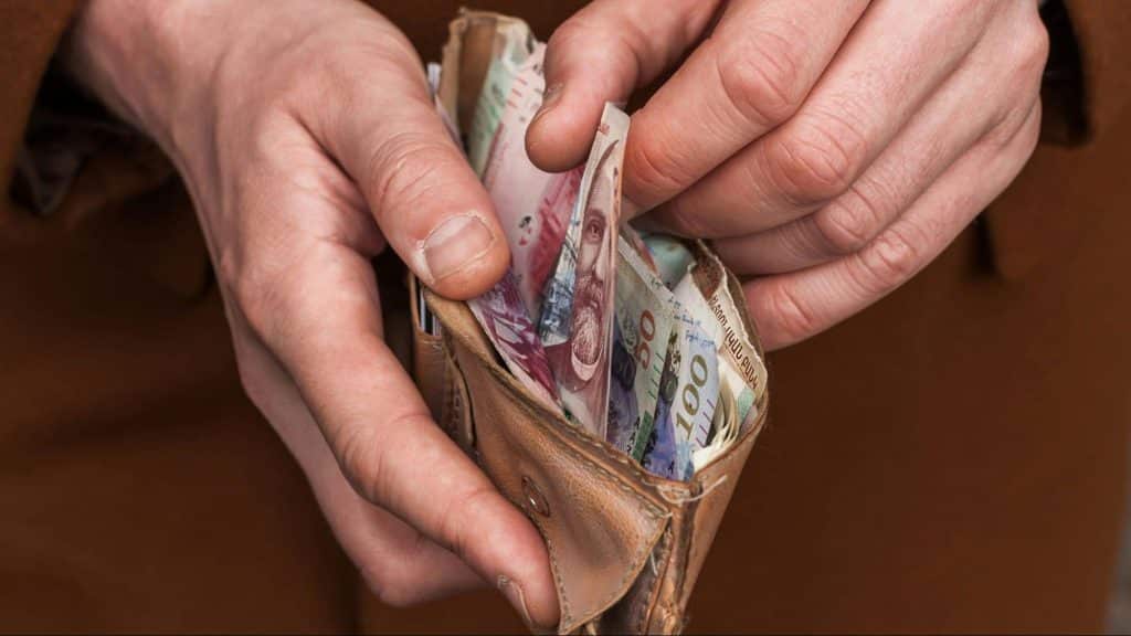 A man holding a wallet with money on it