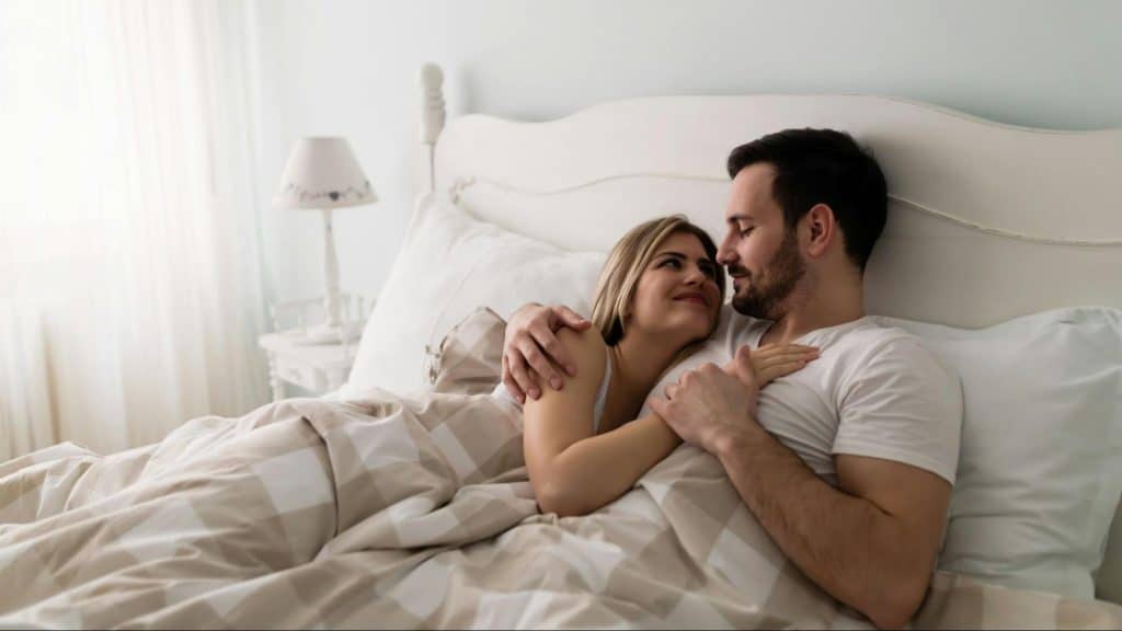 A man and woman having a serious conversation while at the bed
