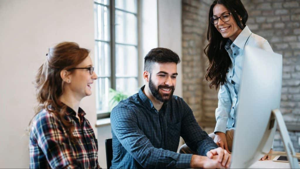A man at the office with  women surrounding him