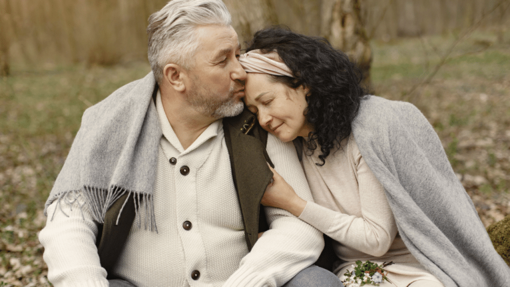A man giving his wife a forehead kiss