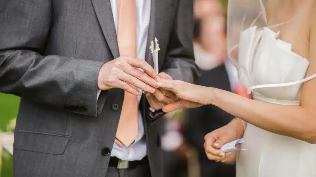 A close-up of a couple exchanging rings during a wedding ceremony.
