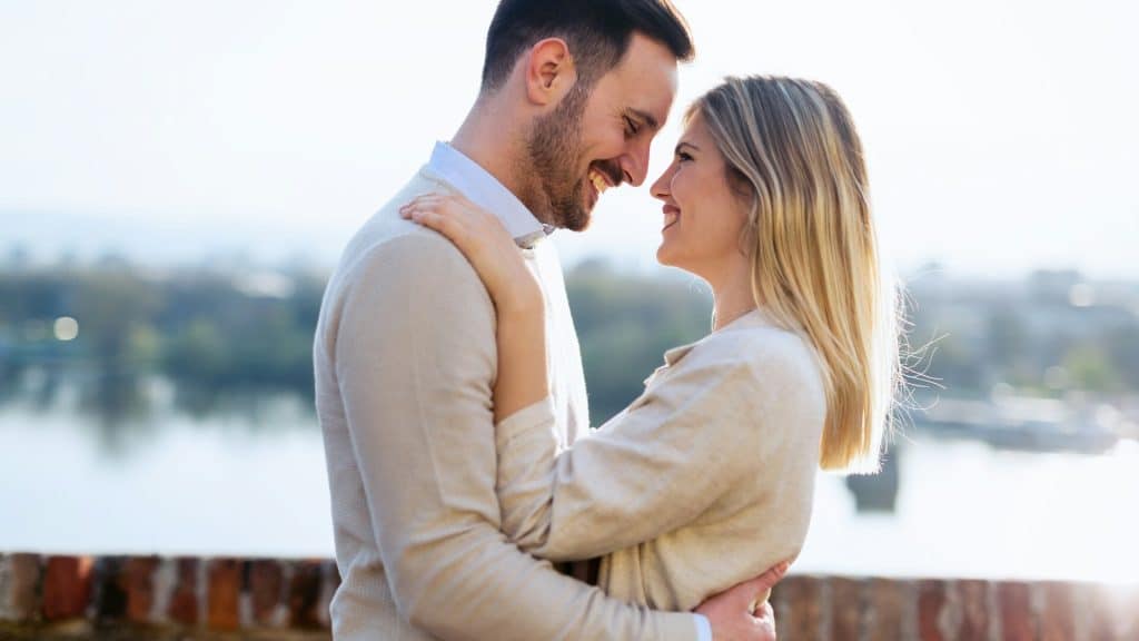 A mature couple embracing each other at the park.