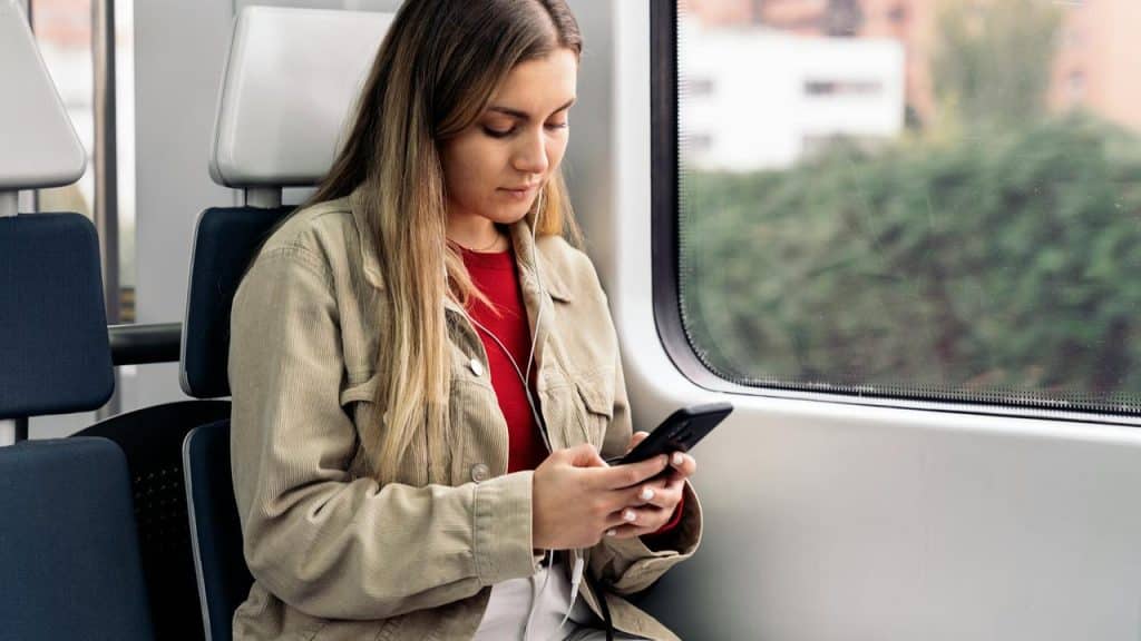 A woman using her phone on a train.