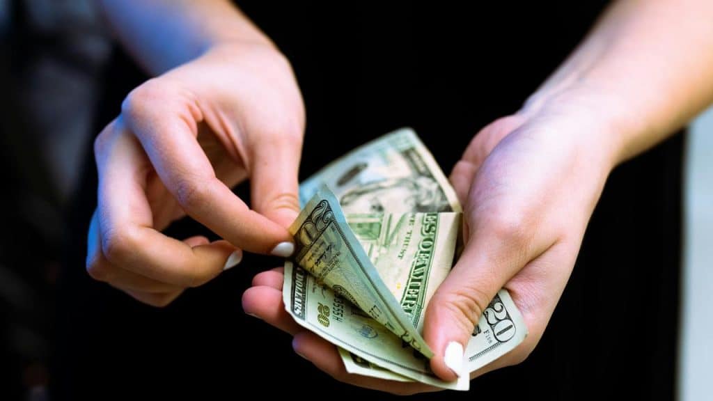 A person counts U.S. dollar bills.