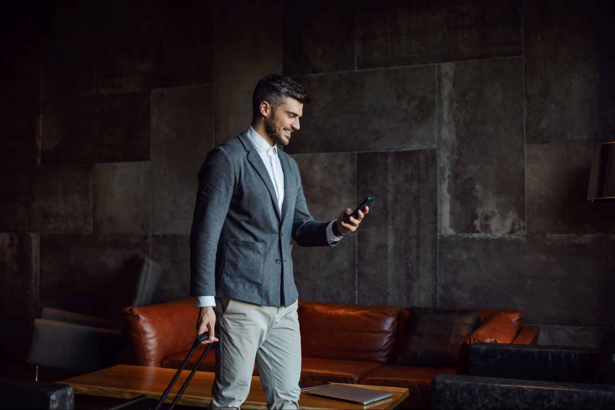 A man smiling while holding a phone