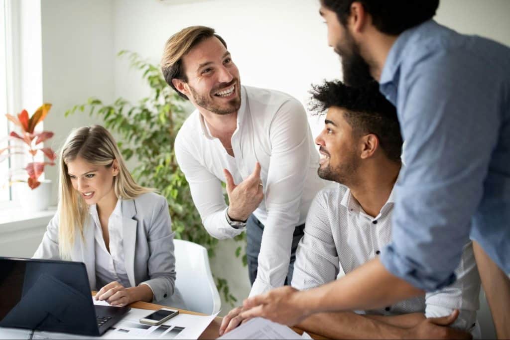 Three men talking about the woman beside them