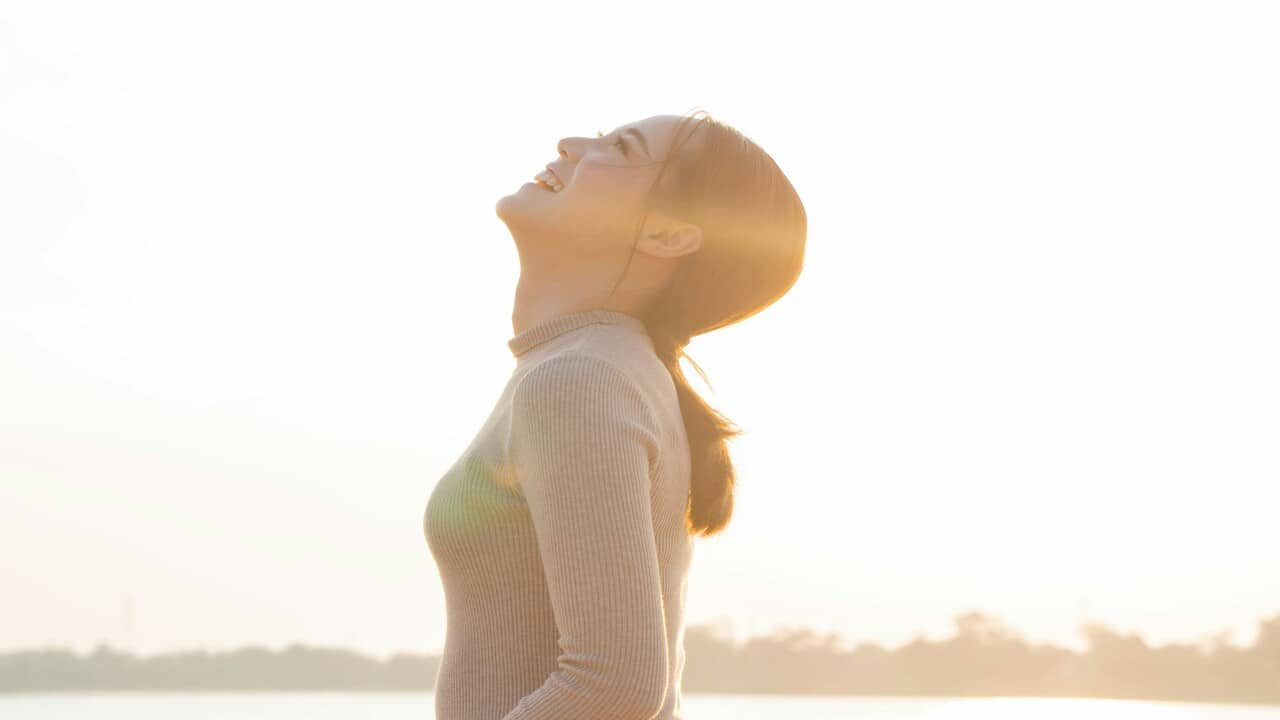 A woman having a deep breath outdoors