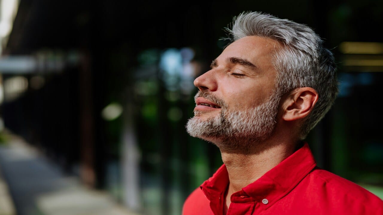 A handsome mature man taking a deep breath