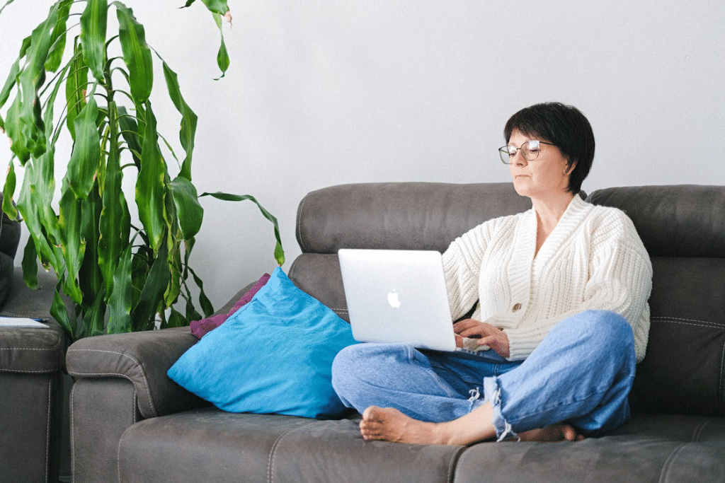 A woman using a laptop on a sofa