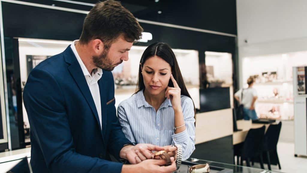 A man and a woman purchasing a watch at a store.