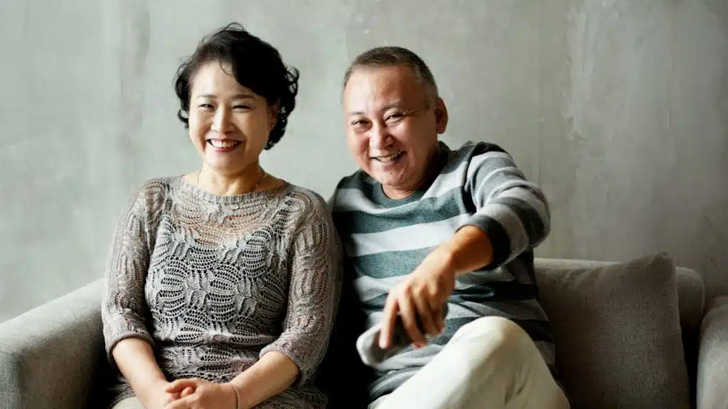 A mature couple sitting together indoors.
